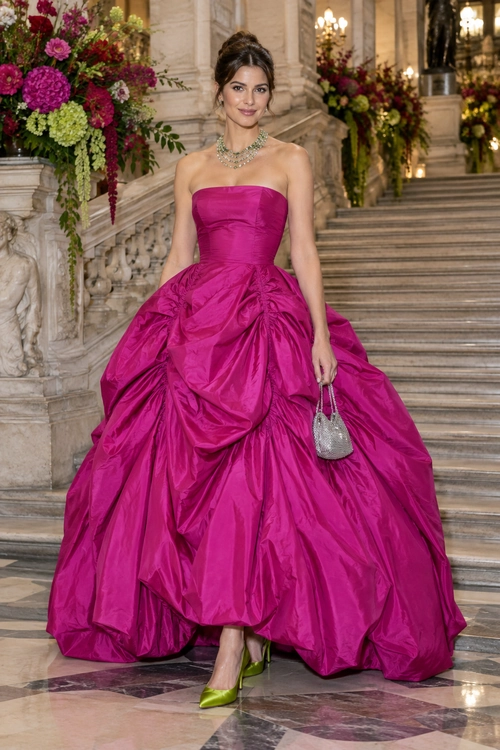 Fuchsia Strapless Ball Gown A strapless fuchsia ball gown with a voluminous gathered skirt, styled with a jeweled necklace, silver clutch, and lime green heels.