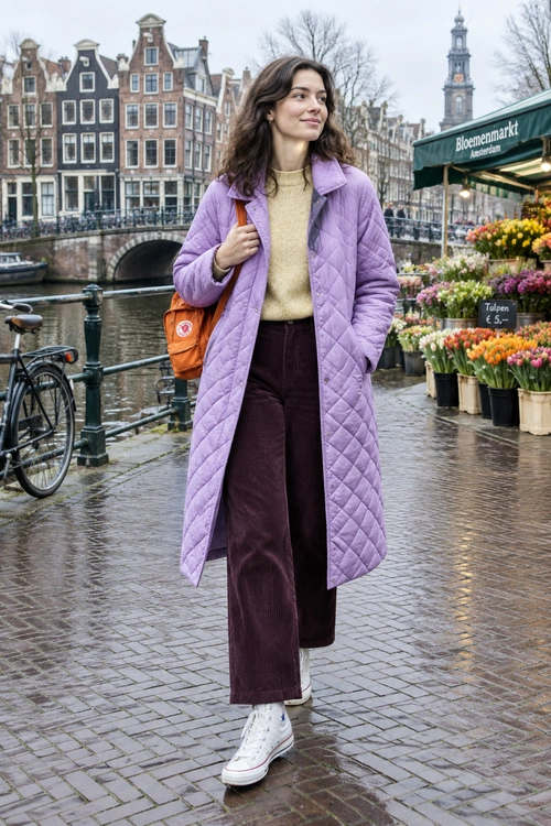 Lilac Quilted Coat Outfit A lilac quilted coat layered over a pale yellow sweater and plum corduroy trousers, with white high-top sneakers and an orange shoulder bag.